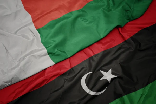 Waving colorful flag of libya and national flag of madagascar. — Stock Photo, Image