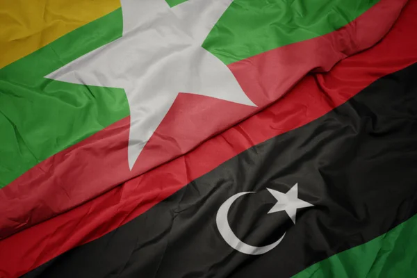 Ondeando colorida bandera de libya y bandera nacional de myanmar . — Foto de Stock