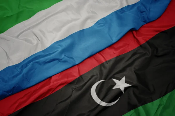 Waving colorful flag of libya and national flag of sierra leone. — Stock Photo, Image