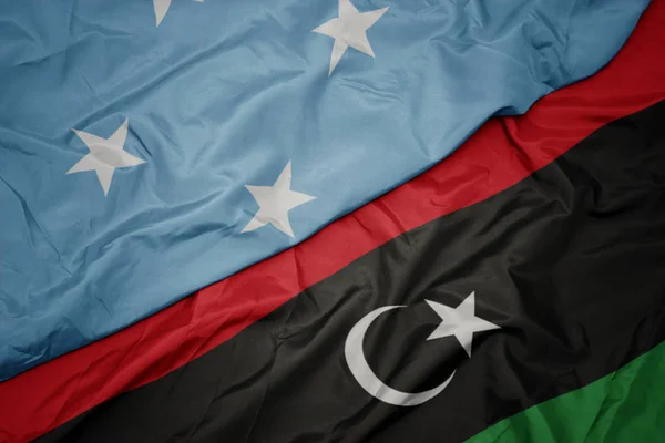 リビアのカラフルな旗とミクロネシア連邦の国旗を振って . — ストック写真