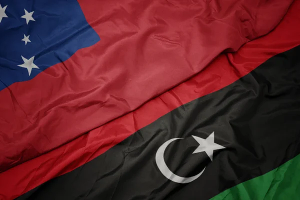 Ondeando colorida bandera de libya y bandera nacional de Samoa  . — Foto de Stock