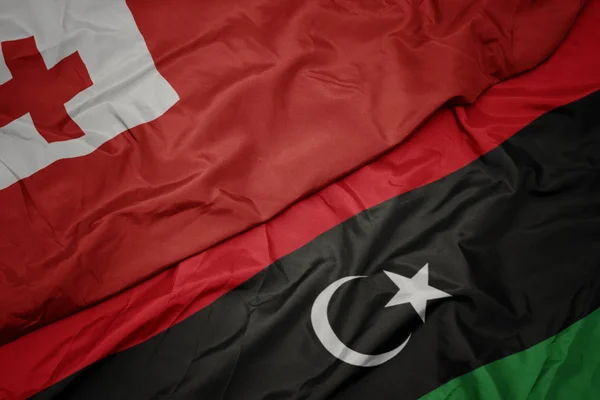 Waving colorful flag of libya and national flag of Tonga . — Stock Photo, Image