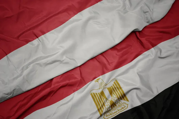 Mávání barevnou vlajkou egyptské a národní vlajky indonésie. — Stock fotografie