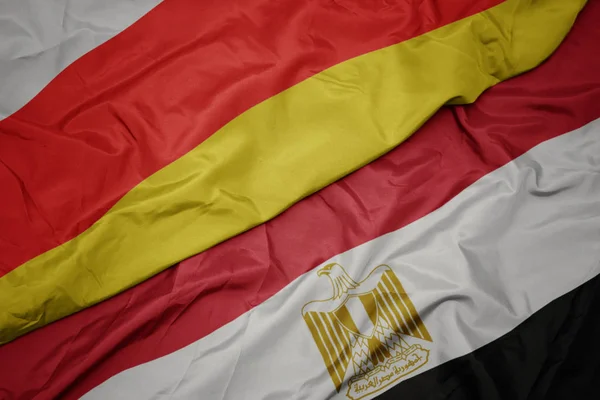 Wapperende vlag van Egypte en nationale vlag van Zuid-ossetië. — Stockfoto