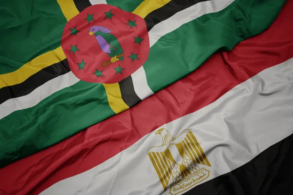 Zwaaiende vlag van Egypte en nationale vlag van Dominica. — Stockfoto