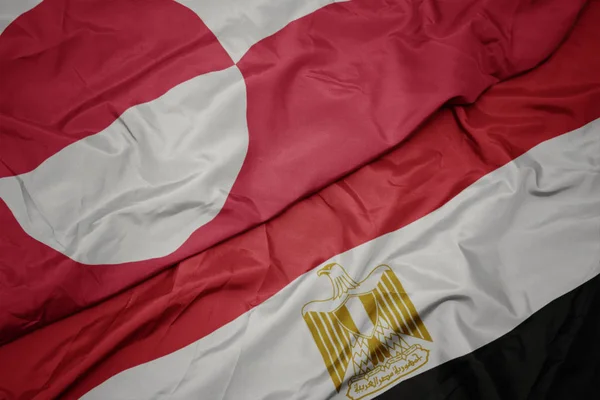 Zwaaiende vlag van Egypte en nationale vlag van Groenland. — Stockfoto