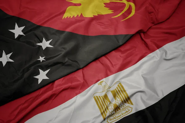 Wapperende vlag van Egypte en nationale vlag van Papoea-Nieuw-Guinea . — Stockfoto