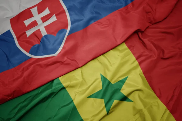 Waving colorful flag of senegal and national flag of slovakia. — Stock Photo, Image