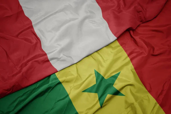 Schwenken bunte senegalesische und peruanische Nationalflagge. — Stockfoto