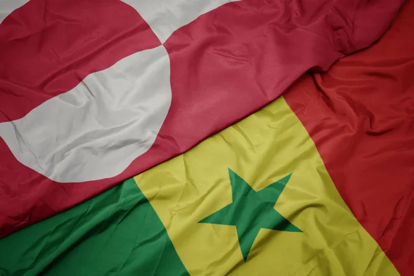 Schwenken bunte senegalesische und grönländische Nationalflagge. — Stockfoto