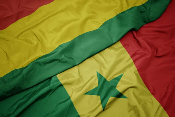 Waving colorful flag of senegal and national flag of bolivia. — Stock Photo, Image
