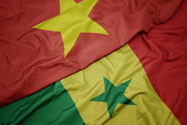 Ondeando colorida bandera de senegal y bandera nacional de vietnam . — Foto de Stock