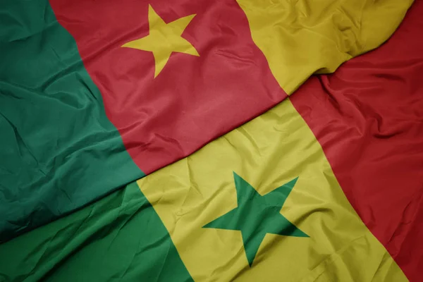 Ondeando colorida bandera de senegal y bandera nacional de camerún . — Foto de Stock