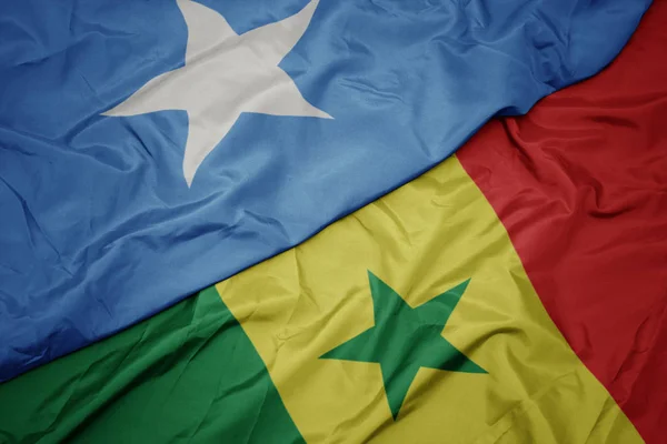 Schwenken bunte senegalesische und somalische Nationalflagge. — Stockfoto
