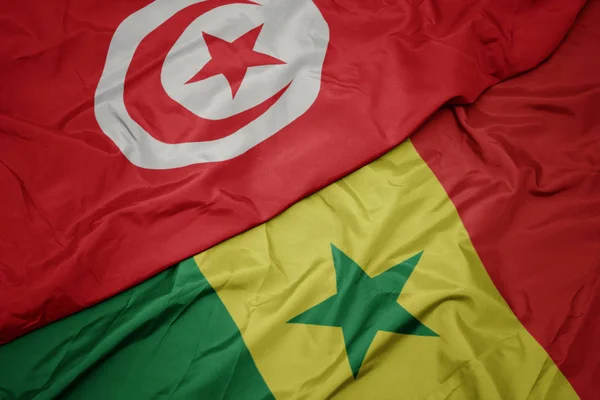 Waving colorful flag of senegal and national flag of tunisia. — ストック写真