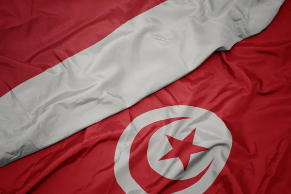 Waving colorful flag of tunisia and national flag of indonesia. — Stock Photo, Image