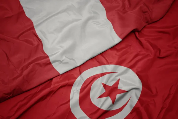 Waving colorful flag of tunisia and national flag of peru. — Stock Photo, Image