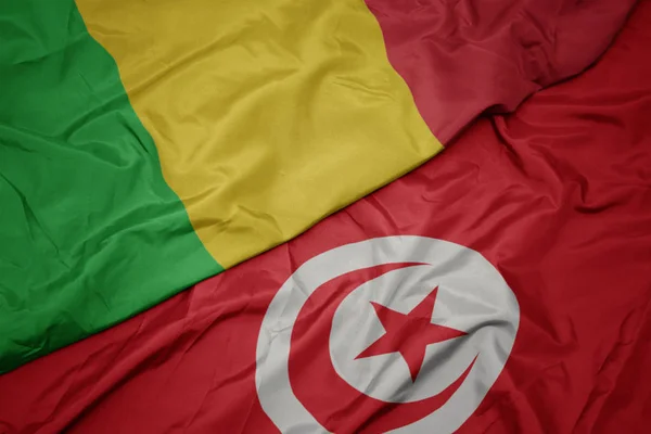 Waving colorful flag of tunisia and national flag of mali. — ストック写真