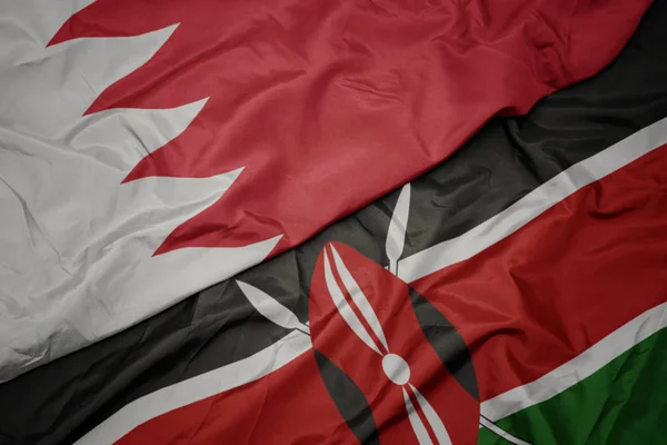 waving colorful flag of kenya and national flag of bahrain.