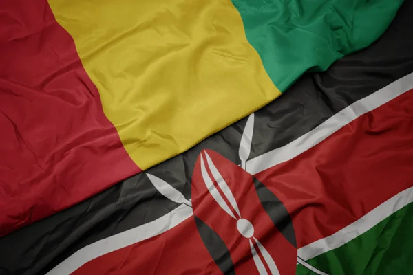 Agitant drapeau coloré du Kenya et drapeau national de la Guinée . — Photo