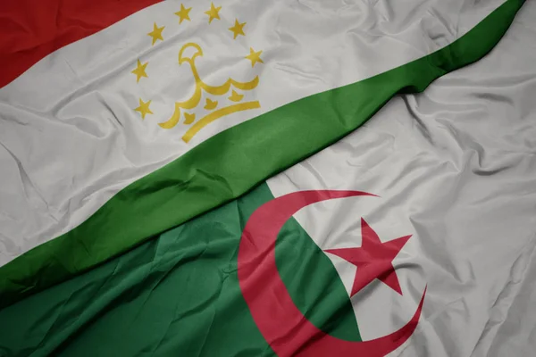 waving colorful flag of algeria and national flag of tajikistan.