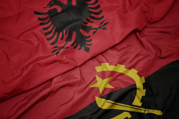 Angola 'nın renkli bayrağını sallayarak ve ulusal Arnavutluk bayrağını sallayarak. — Stok fotoğraf