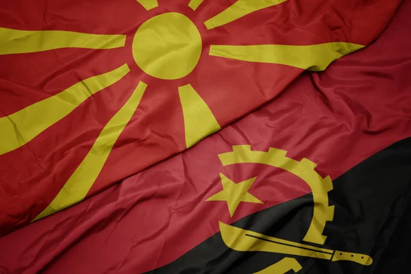 Ondeando colorida bandera de angola y bandera nacional de macedonia . —  Fotos de Stock