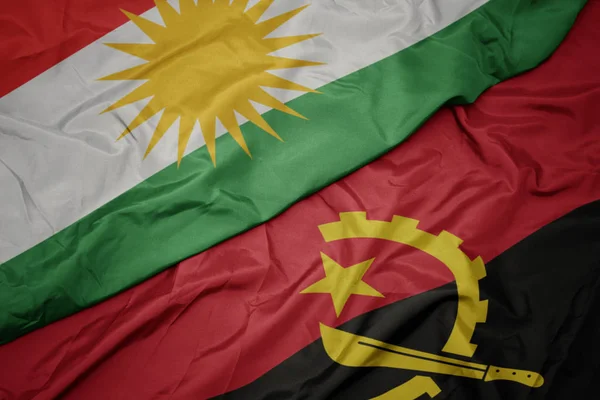 Machanie barwną flagą angoli i flagą narodową kurdystanu. — Zdjęcie stockowe