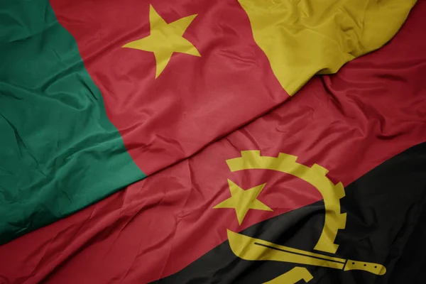 Ondeando colorida bandera de angola y bandera nacional de camerún . — Foto de Stock