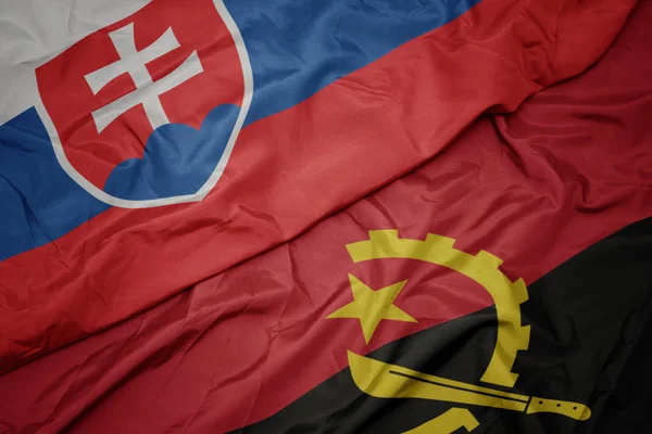 Sventolando bandiera colorata di angola e bandiera nazionale della Slovacchia . — Foto Stock