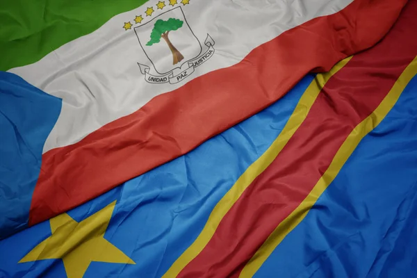 Vlající barevnou vlajkou Demokratické republiky Kongo a národní vlajkou rovníkové perličky. — Stock fotografie