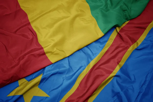 Viftar med färgglada flagga demokratisk republik congo och nationell flagga guinea. — Stockfoto