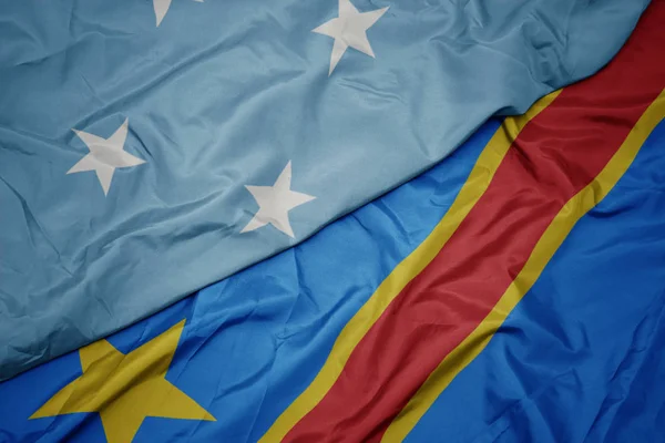 Viftande färgglada flagga demokratisk republik av congo och nationell flagga federerade stater i Mikronesien . — Stockfoto