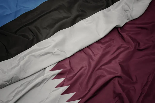 Schwenken bunte Flagge von Katar und Nationalflagge von Estland. — Stockfoto