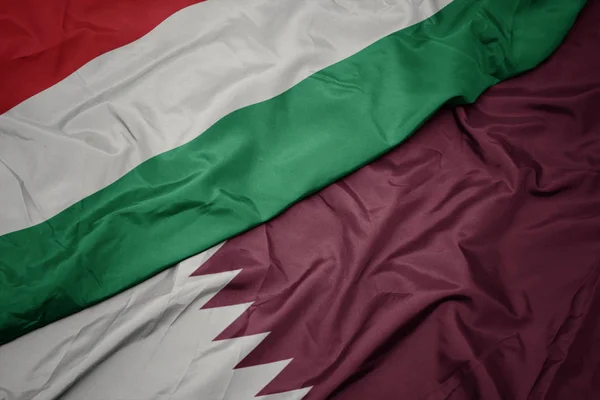 Waving colorful flag of qatar and national flag of hungary. — Stock Photo, Image