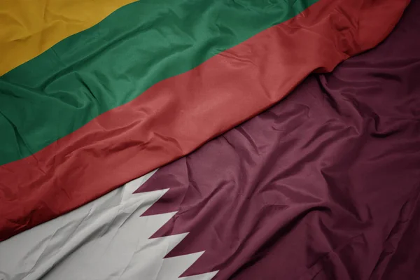 Mávající barevnou vlajkou Kataru a národní vlajkou Litvy. — Stock fotografie
