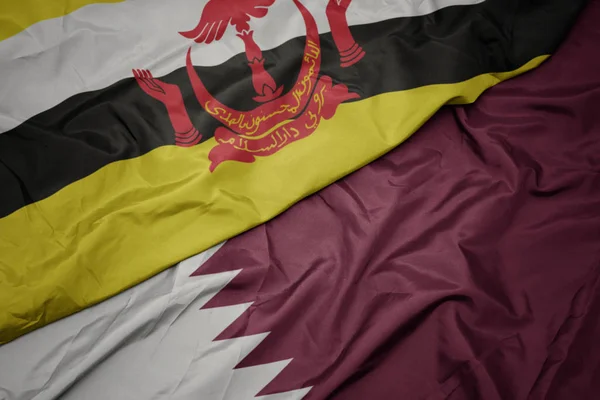 Agitant drapeau coloré de qatar et drapeau national de brunei . — Photo