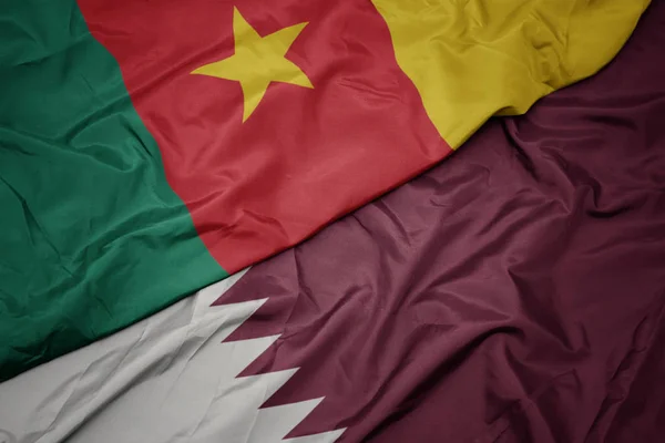 Ondeando colorida bandera de qatar y bandera nacional de camerún . — Foto de Stock