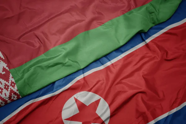 Kuzey Kore 'nin renkli bayrağı ve Belarus' un ulusal bayrağı sallanıyor.. — Stok fotoğraf