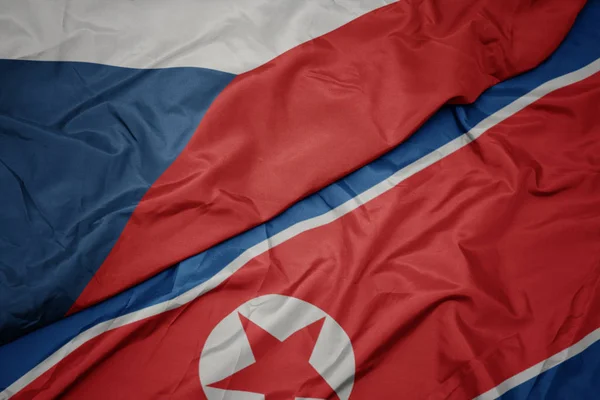 Ondeando colorida bandera de Corea del Norte y bandera nacional de la República Checa . — Foto de Stock