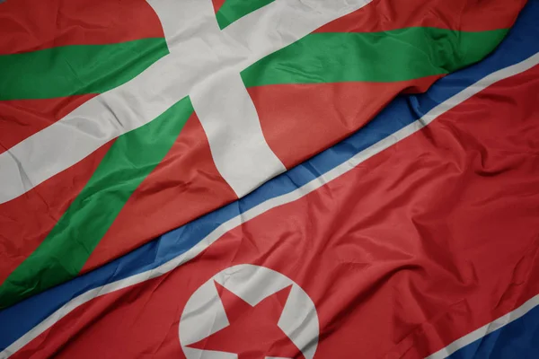 Kuzey Kore 'nin renkli bayrağı ve Bask ülkesinin ulusal bayrağı sallanıyor.. — Stok fotoğraf