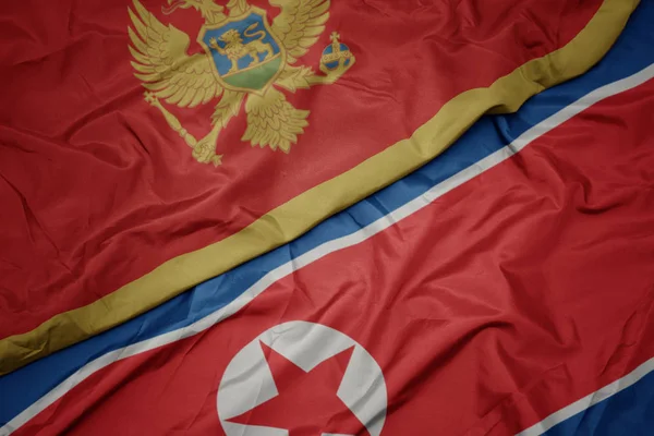 Ondeando colorida bandera de Corea del Norte y bandera nacional de montenegro . — Foto de Stock