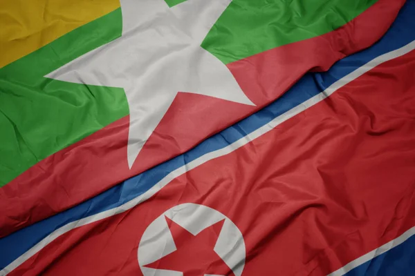 Kuzey Kore 'nin renkli bayrağını sallıyor ve milli miyanmar bayrağını sallıyor. — Stok fotoğraf