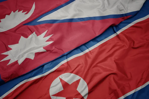 Ondeando colorida bandera de Corea del Norte y bandera nacional de nepal . — Foto de Stock