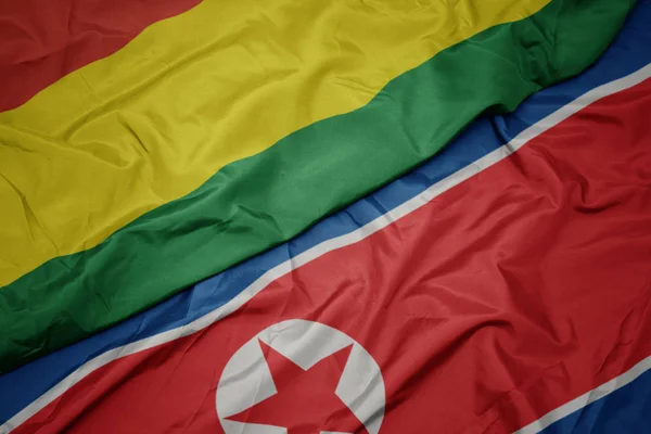 Ondeando colorida bandera de Corea del Norte y bandera nacional de Bolivia . — Foto de Stock