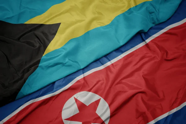 Waving colorful flag of north korea and national flag of bahamas. — Stock Photo, Image