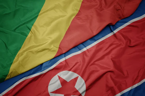 Wapperende vlag van Noord-Korea en nationale vlag van de Republiek Congo. — Stockfoto