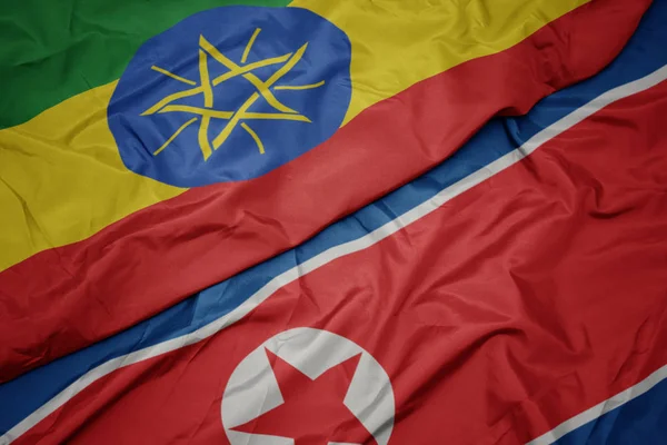Ondeando colorida bandera de Corea del Norte y bandera nacional de Etiopía  . — Foto de Stock