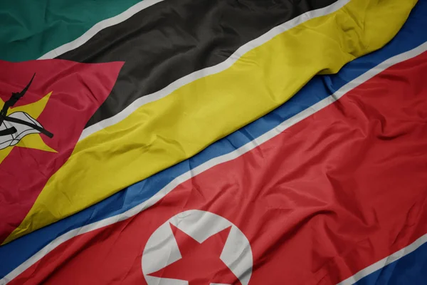 Kuzey Kore 'nin renkli bayrağı ve Mozambik' in ulusal bayrağı sallanıyor.. — Stok fotoğraf