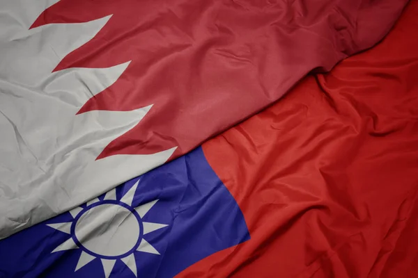 waving colorful flag of taiwan and national flag of bahrain.